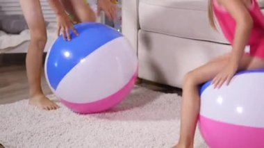 Çocuk iyi eğlenceler oturmak ve büyük lastik şişme top oyun odası atlamak