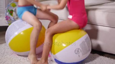 Çocuk iyi eğlenceler oturmak ve büyük lastik şişme top oyun odası atlamak