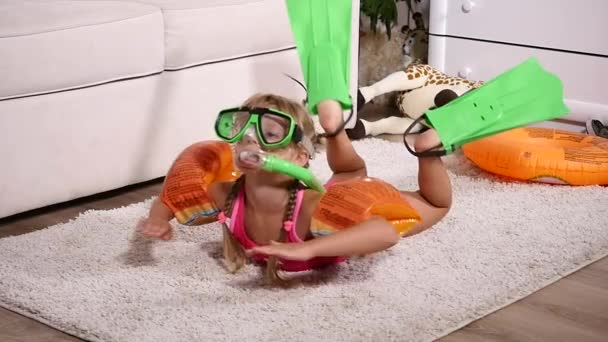 Una chica con una máscara submarina y aletas nadando en la habitación — Vídeo de stock