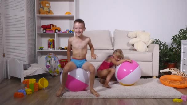 Děti bavit sedět a skákat na velké gumové nafukovací koule v herně