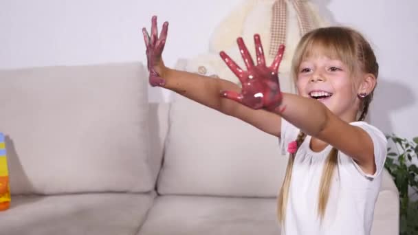 Little girl making hand-prints with paint — Stock Video