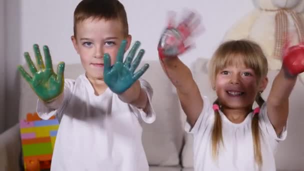 Two joyful kids showing their blotted palms — Stock Video