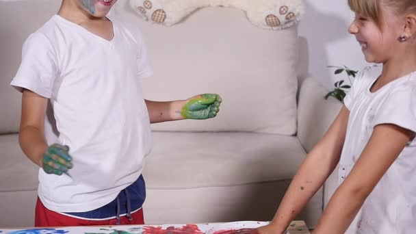 Two little friends smearing paint on each others — Stock Video