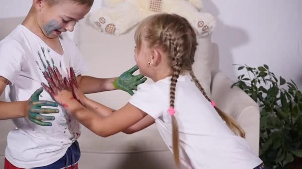 Zwei kleine Freunde beschmieren sich gegenseitig mit Farbe — Stockvideo
