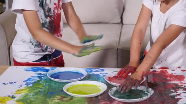 Zwei kleine Freunde beschmieren sich gegenseitig mit Farbe — Stockvideo