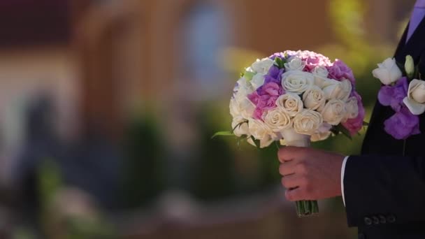 Bruidegom geeft bruiloft boeket aan de bruid — Stockvideo