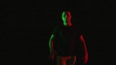 Güzel genç adam neşeli erkek dansçı dans gerçekleştirmek siyah arka plan