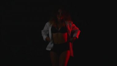 Kırmızı saç giyen açık uzun kollu gömlek ve seksi karanlık iç çamaşırlarına studio ile mutlu ince genç kadın