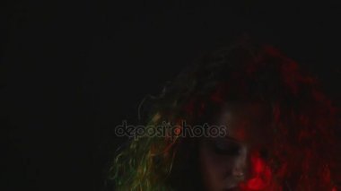 Seksi bir kız bir inç kısa şort ve tişört siyah arka plan üzerine bir sandalyede oturur