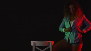 Kısa şort ve tişört sandalye yakınındaki karanlıkta dans seksi kırmızı kadın