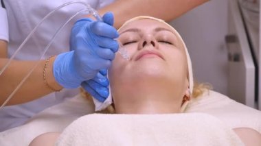 Genç güzel kadın klinik tabloyu, güzellik uzmanı yalan onu yüz elektro-stimülasyon masaj yapar. Kaldırma yordamı, donanım kozmetik. Lüks yaşam tarzı, modeli faaliyetleri