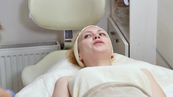 Kobieta leży na kanapie podczas procedury kosmetyczne. Widok z góry — Wideo stockowe