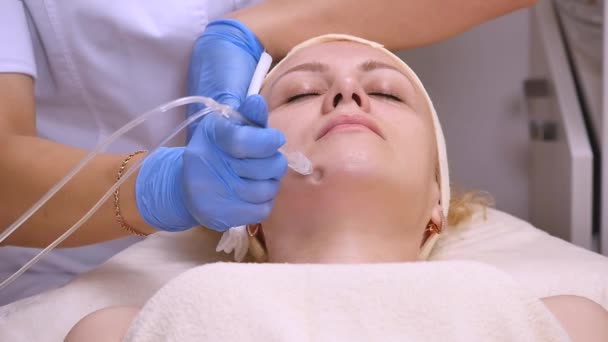 Joven hermosa mujer acostada en la mesa clínica, el cosmetólogo le hace un masaje de electro-estimulación facial. Procedimiento de elevación, cosmetología de hardware. Estilo de vida de lujo, actividades modelo — Vídeos de Stock