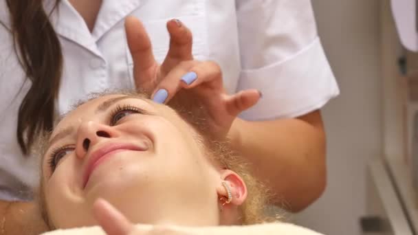 Cosmetician remoção máscara do rosto do cliente no salão de beleza — Vídeo de Stock
