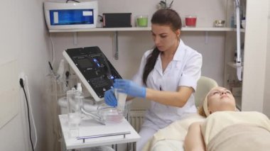 Güzellik uzmanı bir tüp krem bir cam daire sıkar. Medecine eldiven elinde