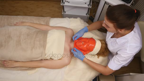 Cosmetician removing mask from client face at beauty salon. Top view — Stock Video