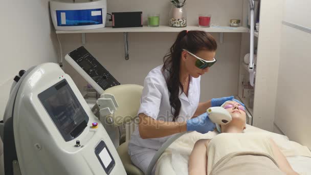 Panning up shot de médico ou terapeuta que administra tratamento a laser de pele fracionada para ressurgir e rejuvenescer uma pele de mulher — Vídeo de Stock