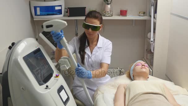 Capture panoramique du médecin ou du thérapeute qui administre un traitement laser à peau fractionnée pour refaire surface et rajeunir une peau de femme. vue de dessus — Video