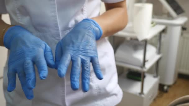 Guantes médicos de látex azul en una mano de mujer — Vídeos de Stock