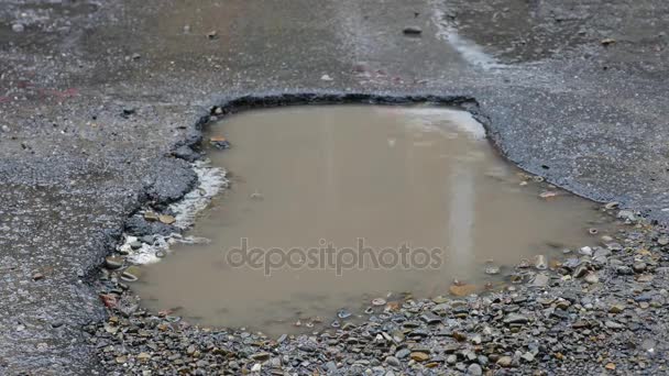 Car Hits Two Pot Holes. slow motion of a car driving through two potholes filled with water — Stock Video