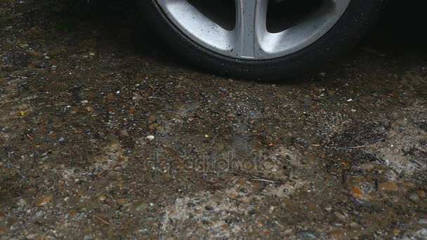 Krople deszczu spadnie w pobliżu koła samochodu — Wideo stockowe