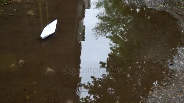 Barco de papel flotando en un charco — Vídeos de Stock