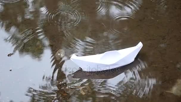 Papierboot schwimmt in einer Pfütze — Stockvideo