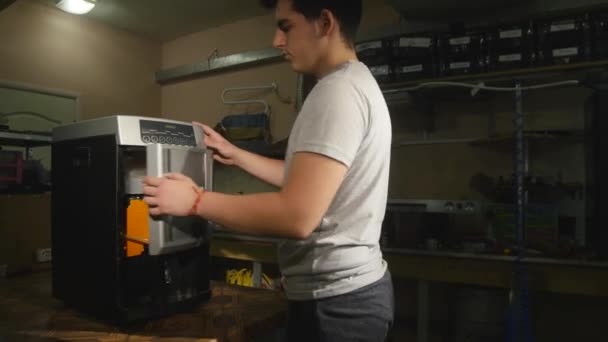 El tipo abre la tapa de la cafetera y saca las bandejas. — Vídeo de stock