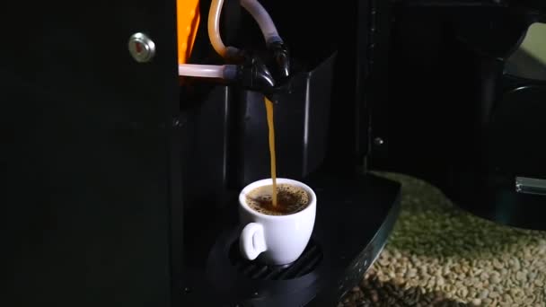 Koffie uitgegoten over de randen van de cup van de koffiemachine — Stockvideo