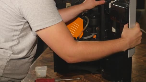 Парень прикрепляет деталь к кофеварке — стоковое видео