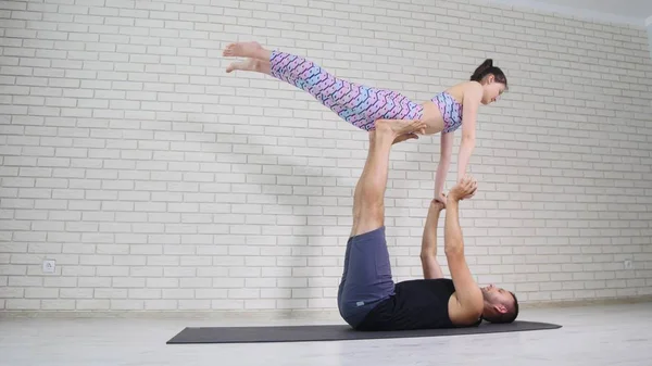 Beautiful couple doing acro yoga in studio — Stock Photo, Image