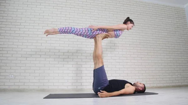 Pasangan indah melakukan yoga akro di studio — Stok Foto