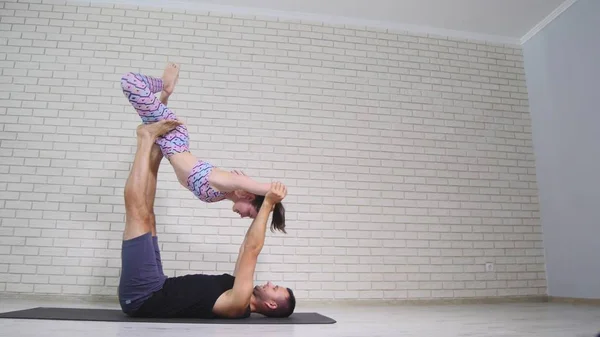 Yoga akrobatik. Wanita muda dan pria melakukan latihan. Kombinasi akrobat dan yoga — Stok Foto