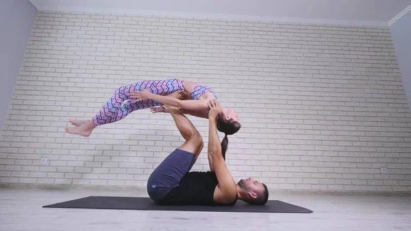 Yoga akrobatik. Wanita muda dan pria melakukan latihan. Kombinasi akrobat dan yoga — Stok Foto