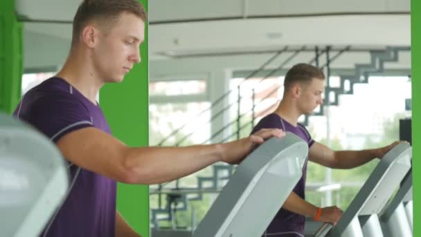 身材健壮的男人开始在体育健身房跑步机上 — 图库视频影像