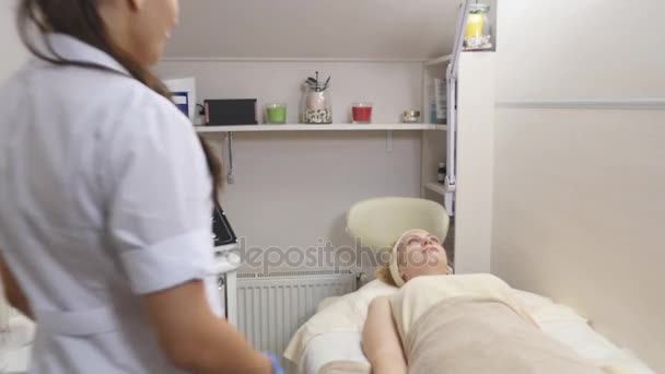 Γυναίκα είναι ξαπλωμένη στον καναπέ κατά τη διάρκεια καλλυντική διαδικασία — Αρχείο Βίντεο