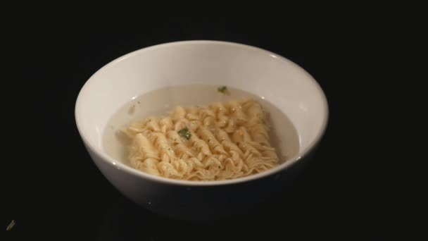 Espaguetis calientes sobre plato blanco con fondo negro. De cerca. — Vídeos de Stock