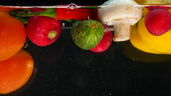 Fekete háttér víz alá tartozó friss zöldségek — Stock Fotó