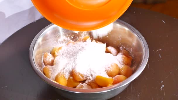 La farine tombe dans une assiette d'abricots avec du sucre — Video