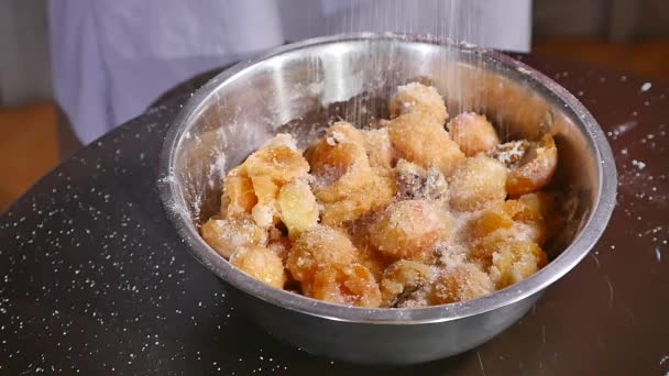 Рука смешивает абрикосы с сахаром, мукой и орехами — стоковое видео