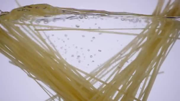 La pasta cade in acqua bollente. Bolle d'acqua bollenti. Bello sfondo acqua — Video Stock