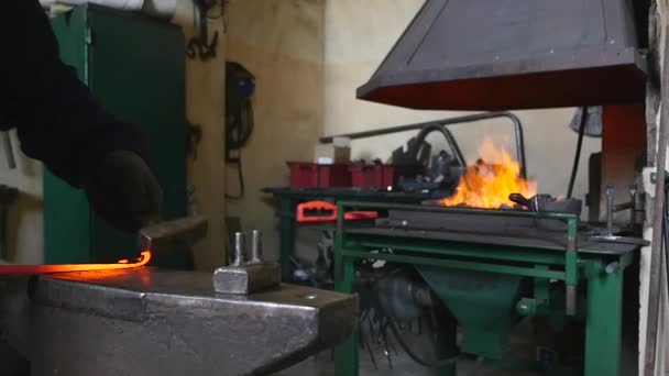 Schmied dreht heißes Metall mit Hammer — Stockvideo