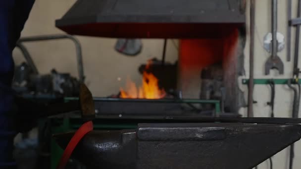 Ferreiro martelando o fim de uma barra de ferro em um gancho — Vídeo de Stock