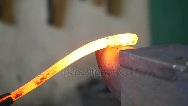 Forgeron plie un bâton chaud de fer avec un marteau — Video