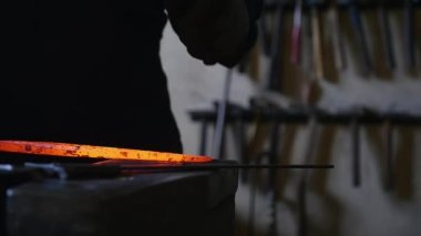 Demirci demir sıcak sopa bir çekiç ile eğiliyor.