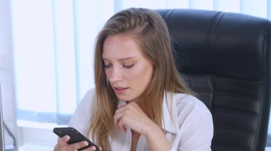 Üzerinde telefon içme kahve app ofiste gülümseyen kullanan akıllı kız. Güzel çok kültürlü genç casual kadın profesyonel üstünde hareket eden telefon