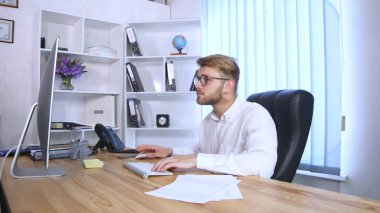 Genç adam ofiste çalışıyor.