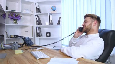 Genç adam ofiste çalışıyor.