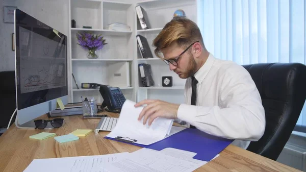 Бизнесмен подписывает документы на офисном столе — стоковое фото