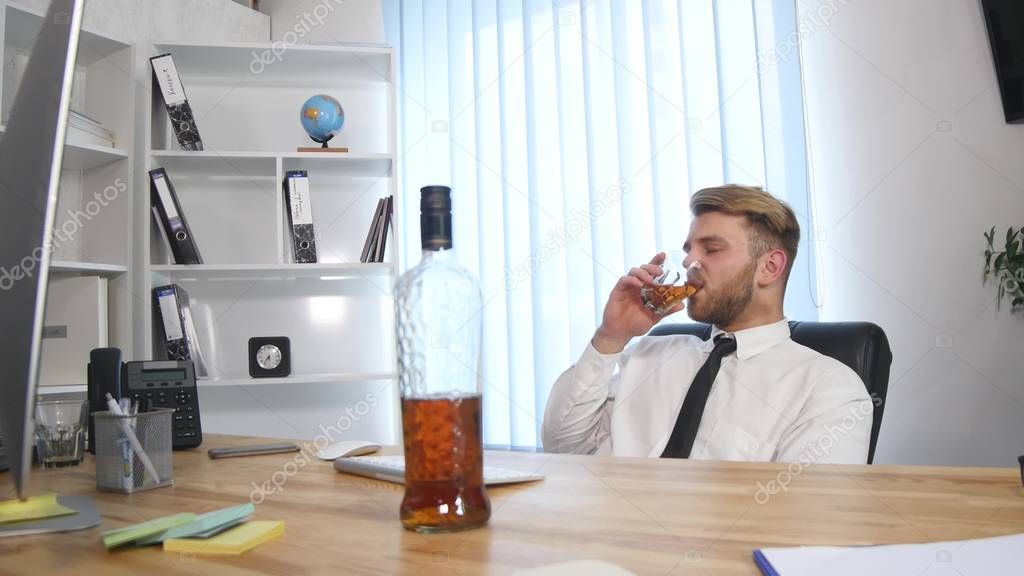 business man drinking alcohol in the office